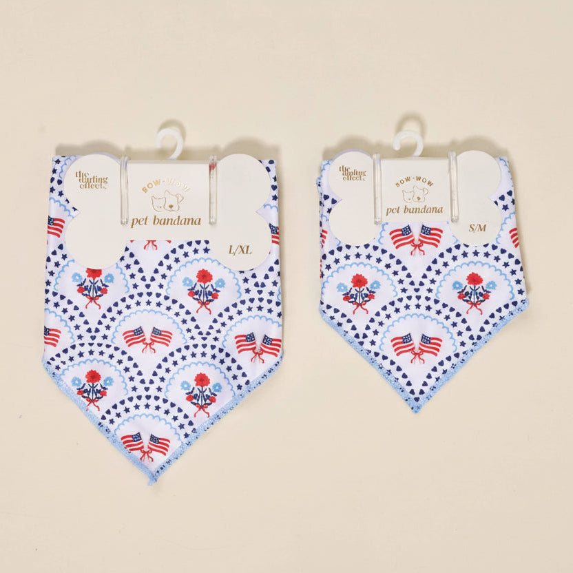 Two pet bandanas with American flag design on hangers against a beige background.